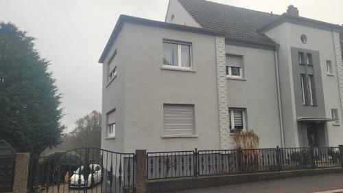 una casa gris con una valla delante de ella en Appartment B 40, en Pirmasens