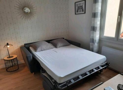 - un lit dans une chambre à côté d'une fenêtre dans l'établissement Le Black and White cosy studio Toulouse centre, à Toulouse