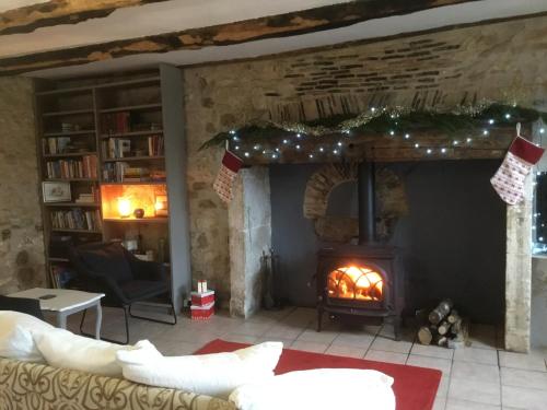 a living room with a fireplace with christmas decorations at Le Chalet in Saint-Front-la-Rivière