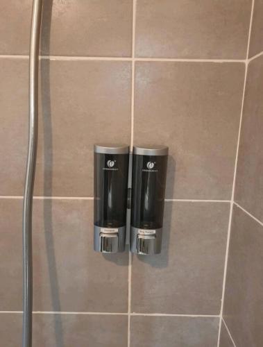 Deux poubelles sont placées sur le mur d'une salle de bains. dans l'établissement Le Black and White cosy studio Toulouse centre, à Toulouse