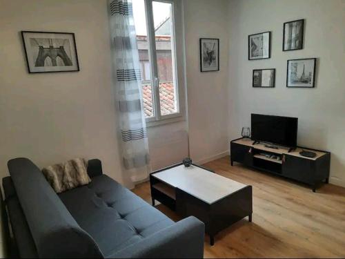 a living room with a couch and a coffee table at Le Black and White cosy studio Toulouse centre in Toulouse
