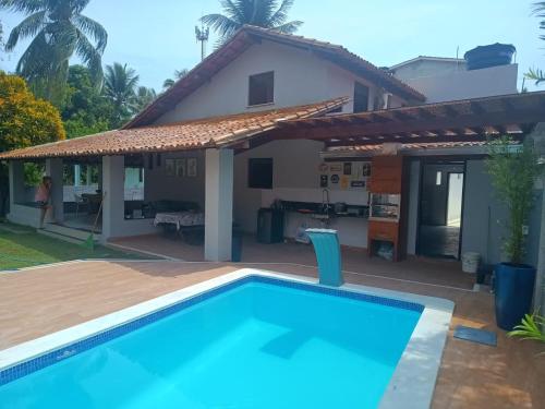 uma villa com piscina em frente a uma casa em Casa da Mari em Vera Cruz de Itaparica