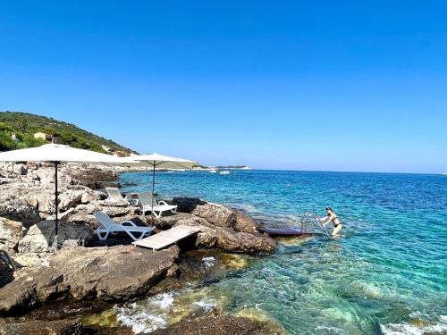 a woman is standing in the water at a beach at Villa Carisma island Vis in Vis