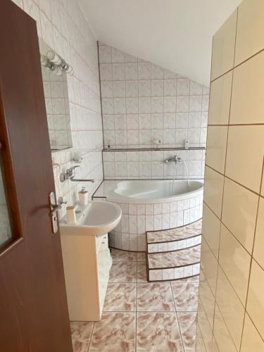 a bathroom with a tub and a sink at Nad Strumykiem APARTAMENT in Ochotnica Dolna