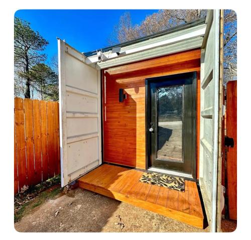 an open door of a tiny house with a porch at Nomehaus shipping container studio residential neighborhood ATHENS in Athens