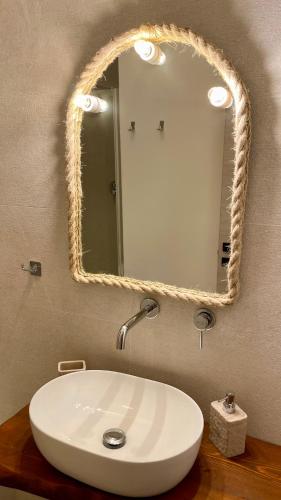 a bathroom with a white sink and a mirror at Cuore di Ognina - Appartamenti vista mare in Ognina