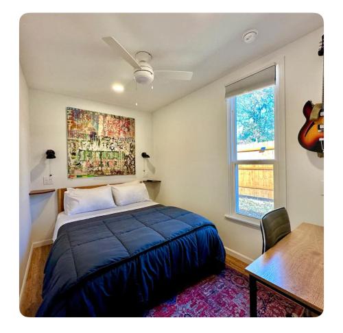 ein Schlafzimmer mit einem Bett, einem Tisch und einer Gitarre in der Unterkunft Nomehaus shipping container studio residential neighborhood ATHENS in Athens