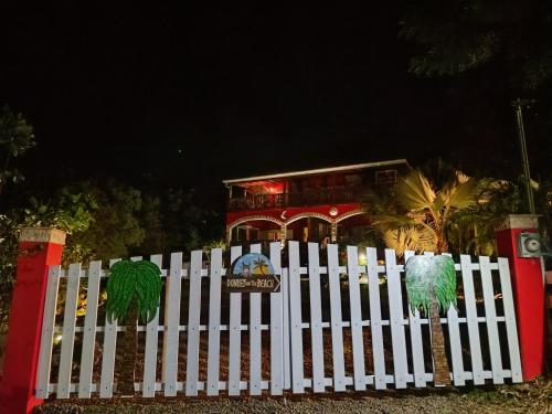 a white fence in front of a house at night at Donkey on the Beach in Cobbs Cross