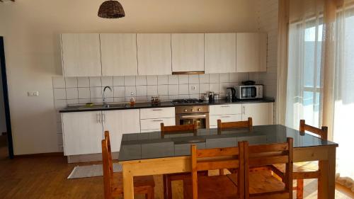 a kitchen with a table and chairs and a kitchen with white cabinets at Kaia Beach House Boa Vista Front Sea View Apartments in Sal Rei