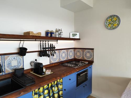 a kitchen with blue cabinets and a stove top oven at Cuore di Ognina - Appartamenti vista mare in Ognina