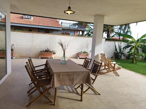 a table with chairs and a vase on a patio at Cuore di Ognina - Appartamenti vista mare in Ognina