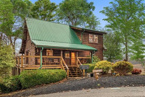 a large wooden house with a green roof at A Moment Inn Time in Pigeon Forge