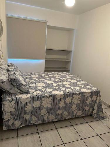 ein Schlafzimmer mit einem Bett in einem Zimmer in der Unterkunft Apartamento de 3 quartos na Praia da Fonte Guarapari in Guarapari