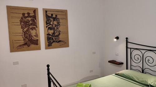 a bedroom with two pictures on the wall and a bed at Cuore di Ognina - Appartamenti vista mare in Ognina