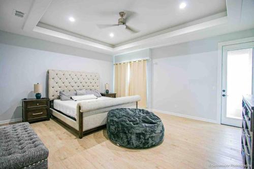 a bedroom with a bed and a ottoman at Cheerful 3-bedroom Residential home with Pool in Mission