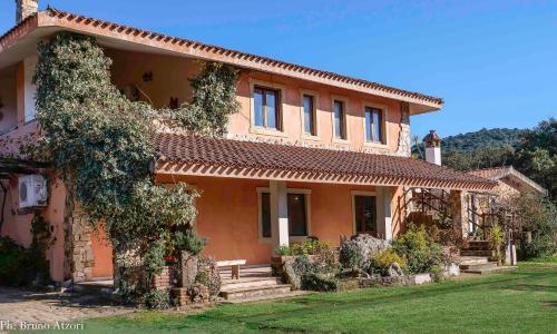 a large orange house with a bench in front of it at Sa Tanchitta in Ulà Tirso