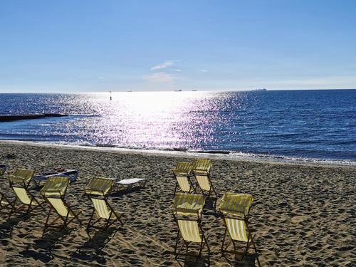 a group of chairs sitting on a beach at Fernhurst holiday apartments in Shanklin