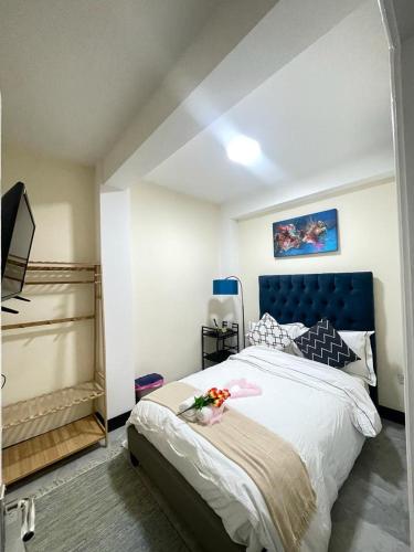 1 dormitorio con 1 cama grande y cabecero azul en Airstaybnb en Mánchester