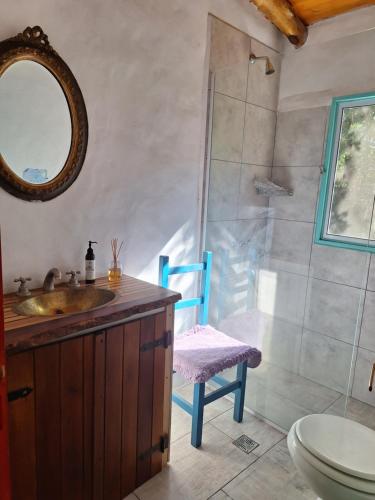 a bathroom with a sink and a shower with a blue chair at Luz de Cabaña in Carpintería