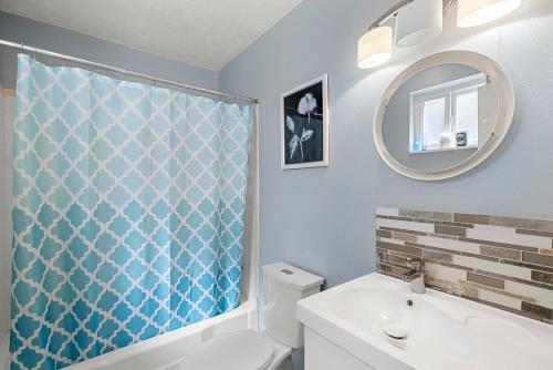 a bathroom with a blue shower curtain and a sink at Casita Rio in Albuquerque