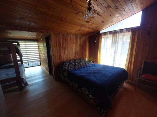 a bedroom with a bed in a wooden room at Grandes cabañas in Pucón