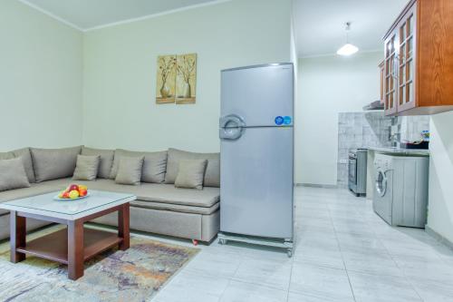 a living room with a couch and a refrigerator at Lazur Sea & City Apartment's - El Hadaba, Hurghada - Egypt in Hurghada