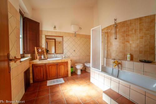 a bathroom with a tub and a toilet and a sink at Sa Tanchitta in Ulà Tirso