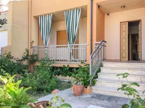 uma casa com escadas e plantas em frente em Posidonia Guest House La Caletta Sardegna em La Caletta