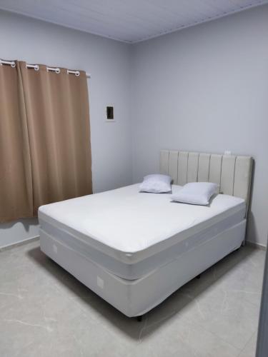 - duże białe łóżko w białym pokoju w obiekcie Casa nas termas de Piratuba w mieście Piratuba