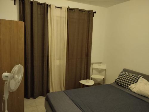 a bedroom with a bed and a window with curtains at Lugar calmo na cidade sol 
