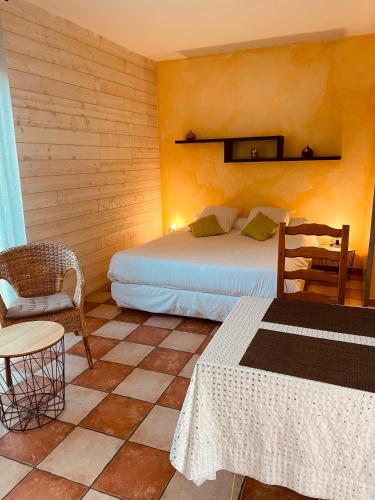 a bedroom with a bed and a chair and a table at L'étape Provencale in Cabriès