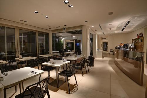 a restaurant with tables and chairs in a room at Boutique Hotel Bali in Lido di Jesolo