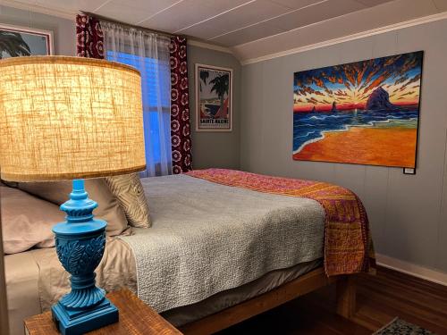 錫賽德的住宿－Seafare，一间卧室配有一张带灯具和绘画的床