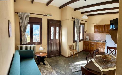 a living room with a blue couch and a kitchen at Giataki in Elati Trikalon