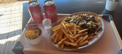 a tray of food with french fries and soda at pousada solar da canastra in Delfinópolis