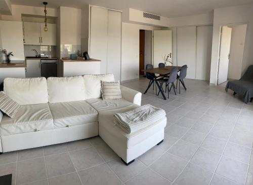 un salon avec un canapé blanc et une cuisine dans l'établissement L’ESCALE APPART 60m2 à 200m de la plage, à Marseille