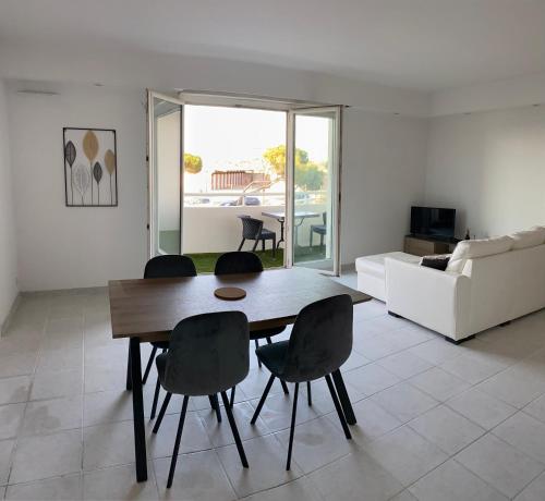 un salon avec une table et des chaises en bois dans l'établissement L’ESCALE APPART 60m2 à 200m de la plage, à Marseille
