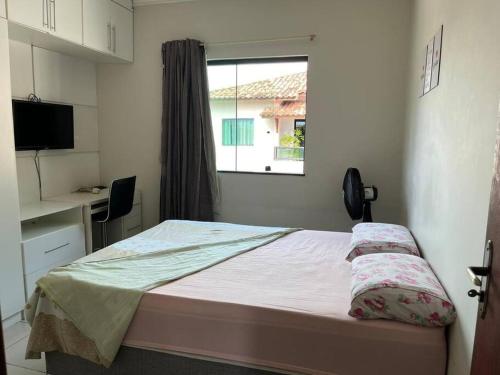 a small bedroom with a bed and a window at Apartamento mobiliado in Porto Seguro