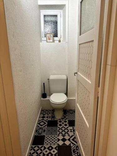 Elle comprend une petite salle de bains pourvue de toilettes et d'une fenêtre. dans l'établissement Appartement rénové entre Saint-Malo et le Mont-Saint-Michel, à Dol-de-Bretagne