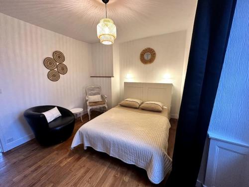a bedroom with a bed and a chair in it at Appartement rénové entre Saint-Malo et le Mont-Saint-Michel in Dol-de-Bretagne