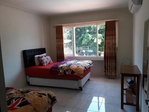a bedroom with two beds and a window at Dannu's Homestay Ijen and Bromo Tour in Banyuwangi