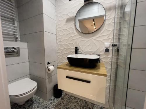 ein Bad mit einem Waschbecken und einem Spiegel in der Unterkunft URBAN APARTMENTS PREMIUM No12 Chorzów, Katowice with PRIVATE PARKING in Chorzów