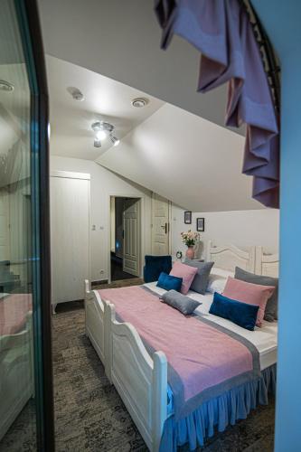 a bedroom with a large bed with blue and pink pillows at Modra Sikorka in Smardzewice