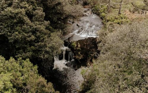 an aerial view of a waterfall in a forest at Casa de Campo Santa Paulina in Urupema