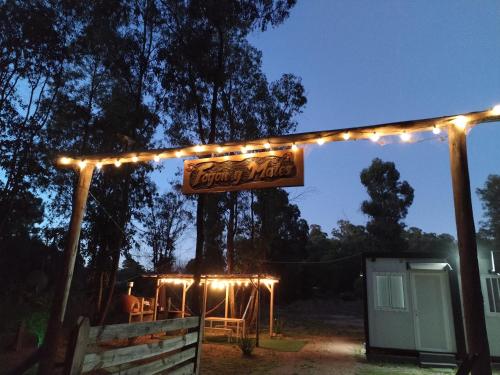 una señal colgando de una pérgola con luces en FOGON Y MATES, en Maldonado