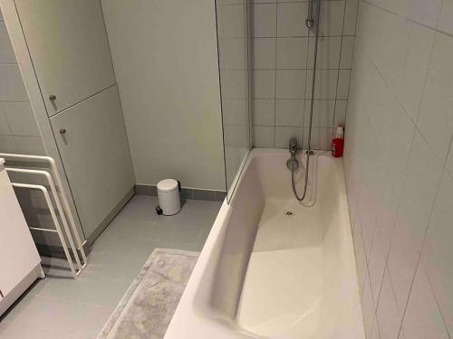 La salle de bains blanche est pourvue d'une douche et d'une baignoire. dans l'établissement Charmant appartement Château d'Oléron, au Château-dʼOléron