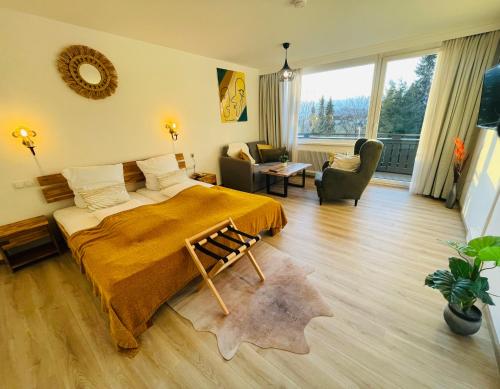 a bedroom with a bed and a living room at Hotel Berghof Graml in Hallwang