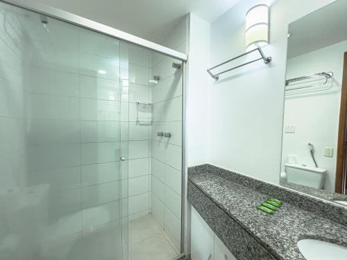 a bathroom with a glass shower and a sink at Suíte Pátio Paulista 14 in São Paulo