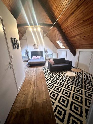 a living room with a bed and a couch at Charmant appartement entre Saint-Malo et le Mont-Saint-Michel in Dol-de-Bretagne