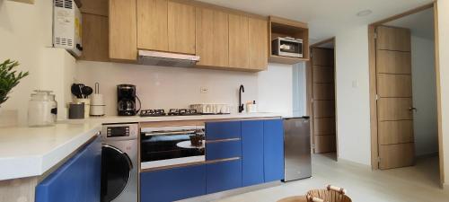 cocina con armarios azules y fogones en Apartamento moderno cerca al aeropuerto, en Bogotá